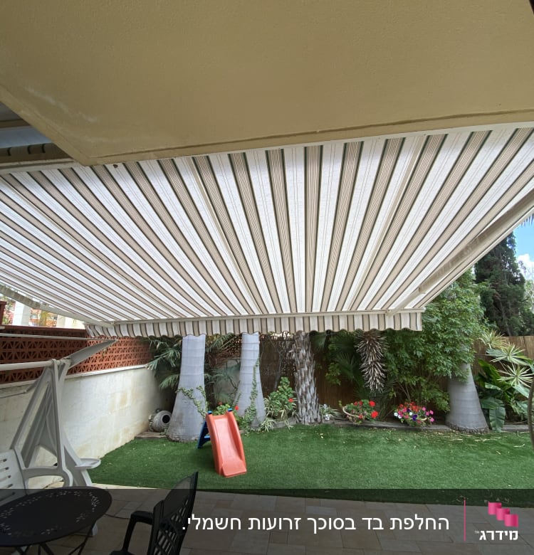 סוכך בד פסים לבן וחום בחצר